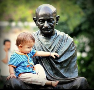 Photo d’une statue de Gandhi avec un bébé bien vivant sur ses genoux.