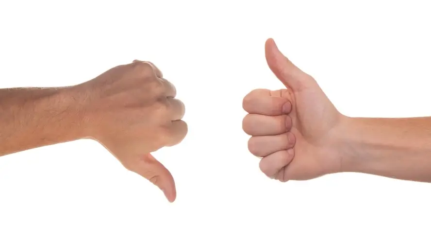 Une main avec le pouce levé et une autre main avec le pouce baissé