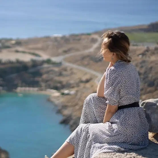 Une dame seule devant un paysage de vacances