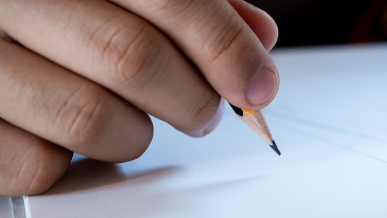 Un main qui écrit sur une feuille de papier