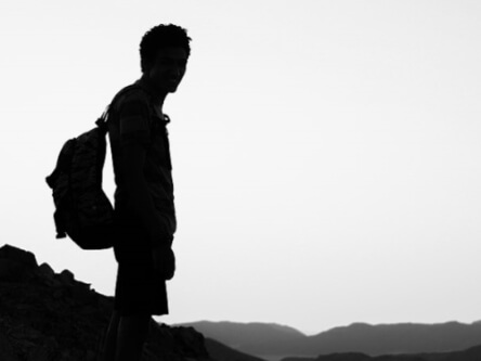 Silhouette noir et blanc d'un homme admirant des montagnes au loin