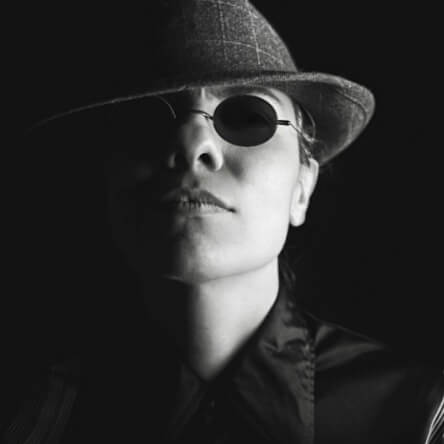 Homme porte un chapeau des années 50 et une attitude menaçante.