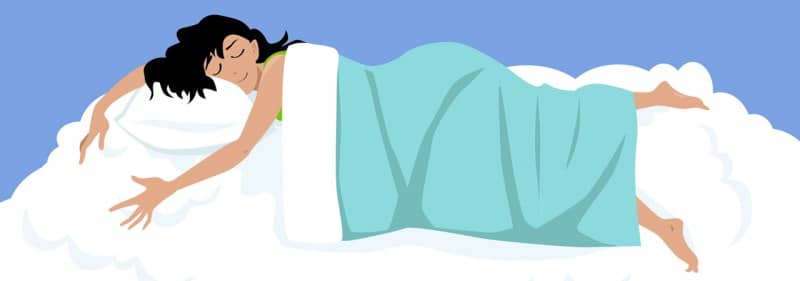 Une dame qui semble heureuse dans un lit.