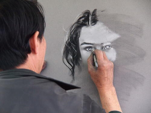 Un artiste peint le visage d’une dame.