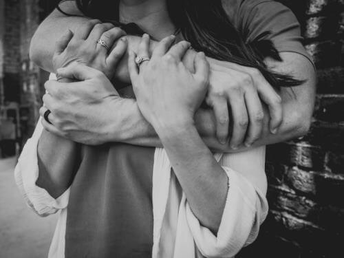 Un homme tient une femme dans ses bras.