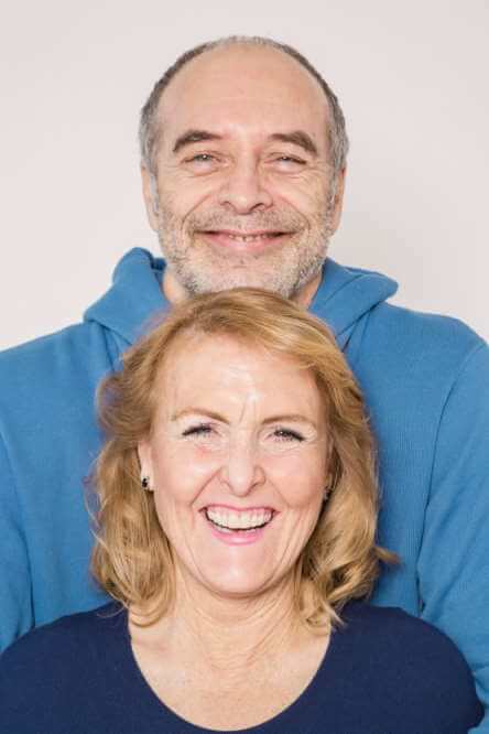 Un couple au-delà de la soixantaine sourit largement.