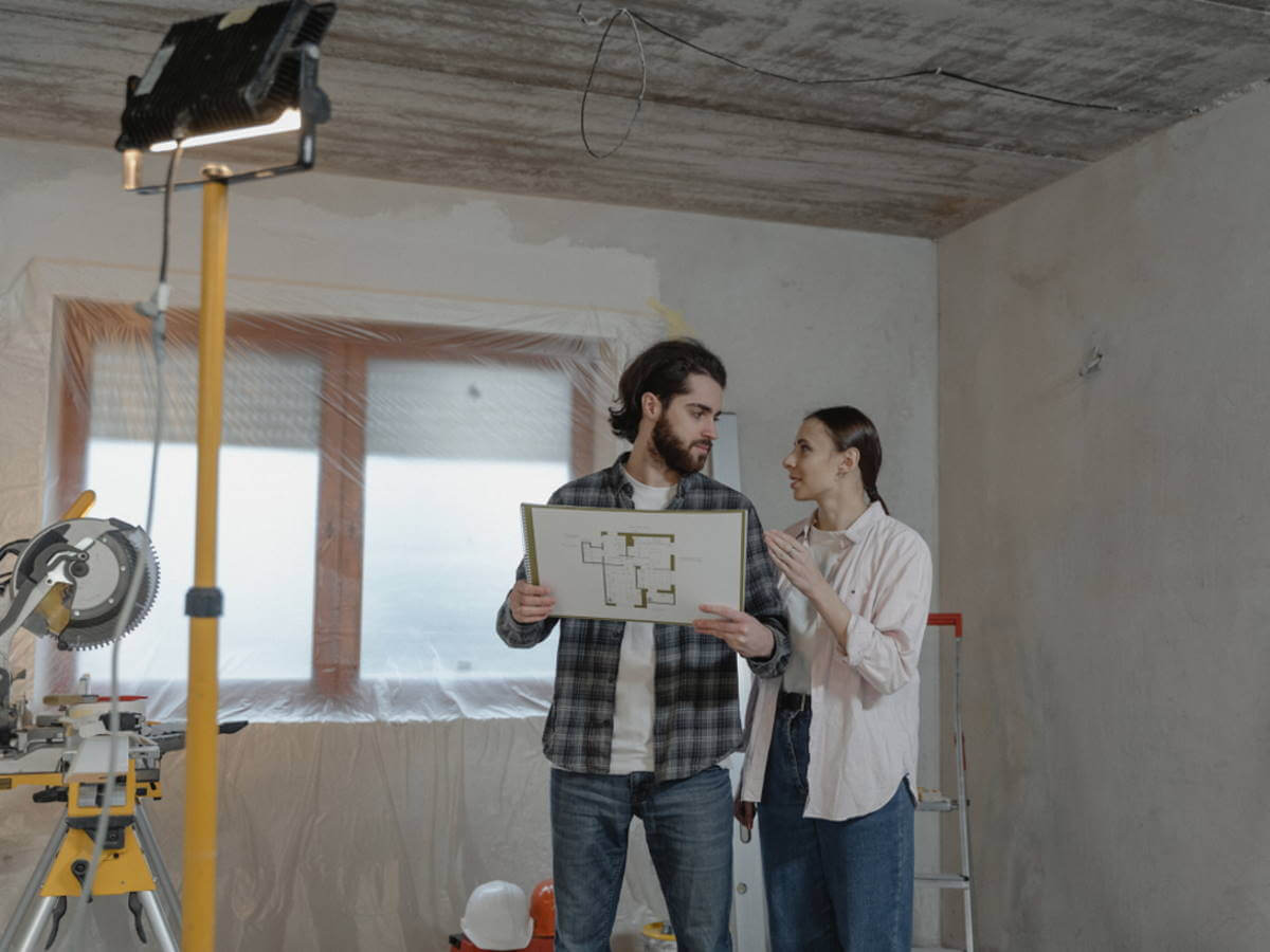 Un jeune couple dans un pièce en rénovation.