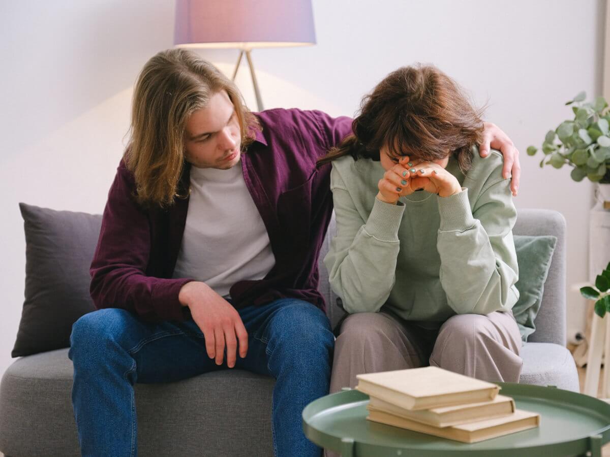 Un homme console une femme qui pleure.