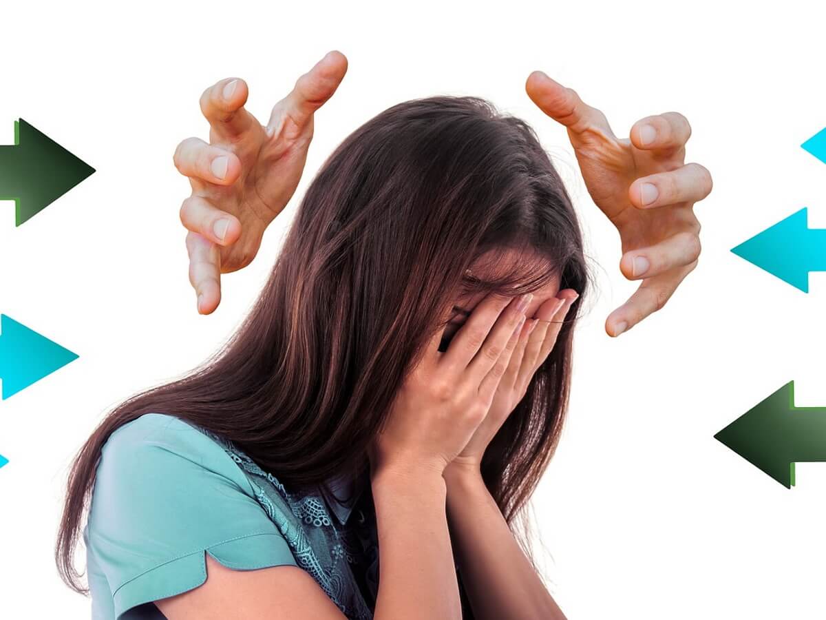 Une jeune femme anxieuse cache son visage avec ses mains.