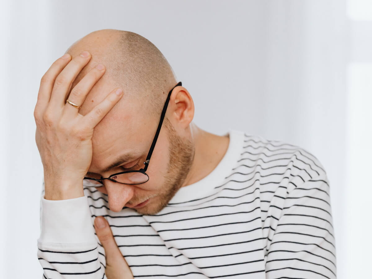 Un homme met la met sur son crâne chauve pour exprimer sa déception.