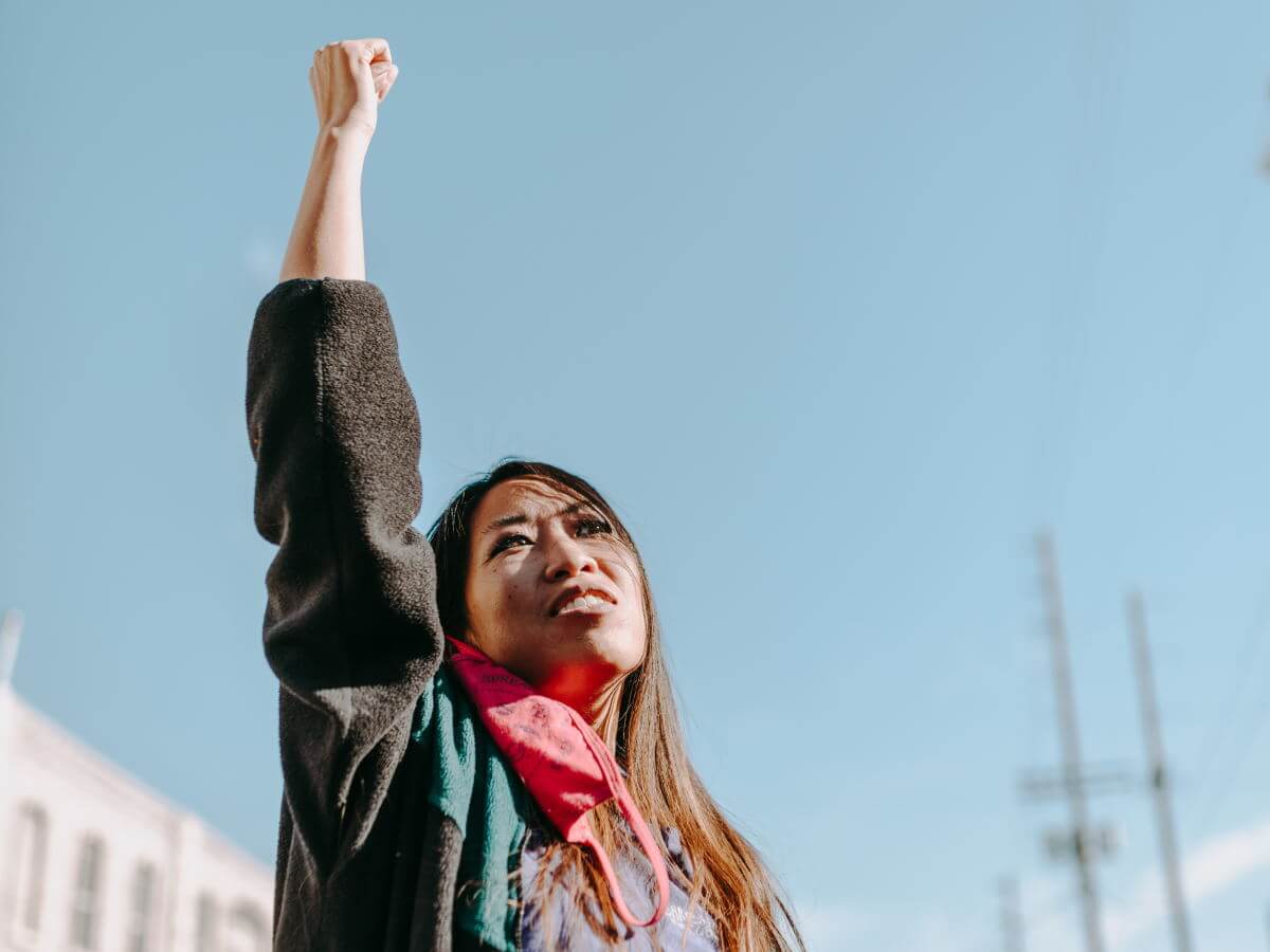 Une jeune femme lève le bras vers le haut.