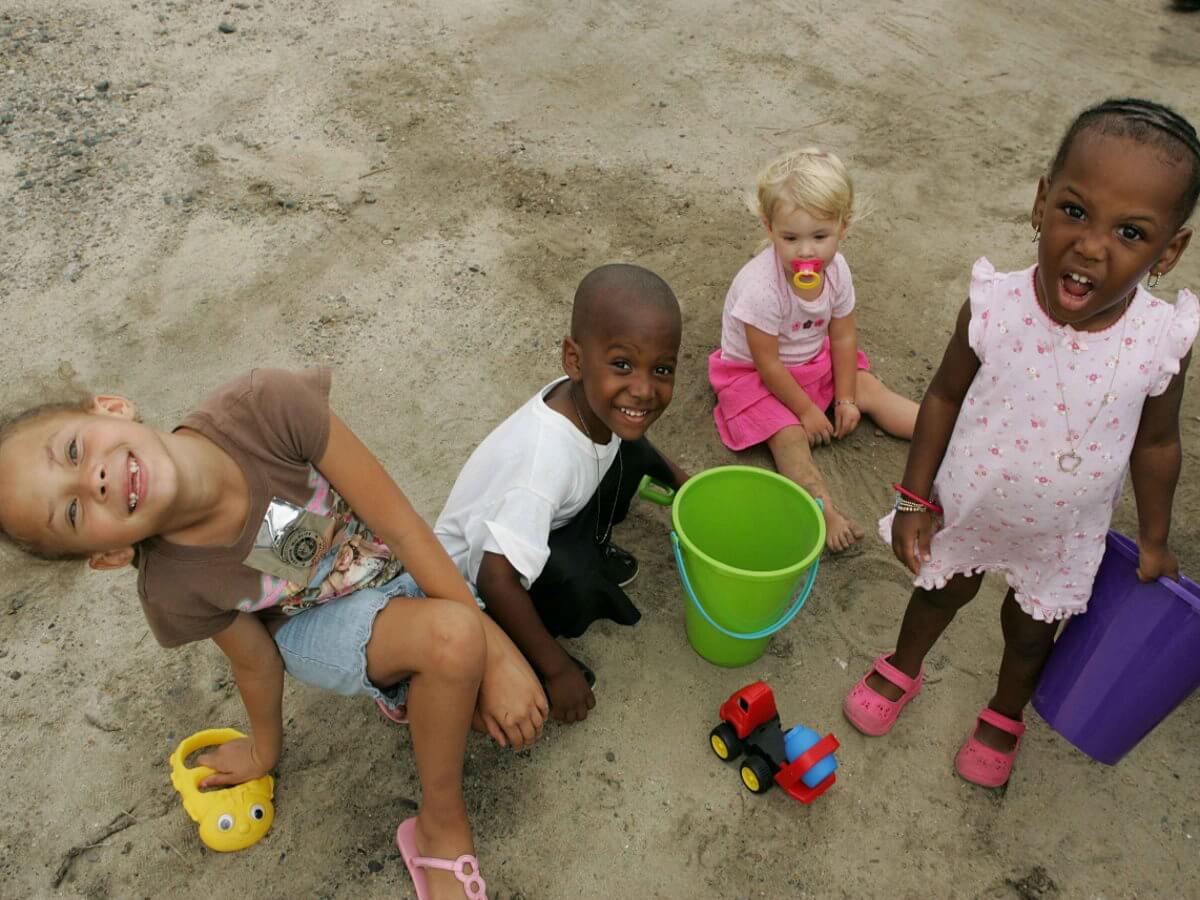 Quatre enfants jouent dans le sable.