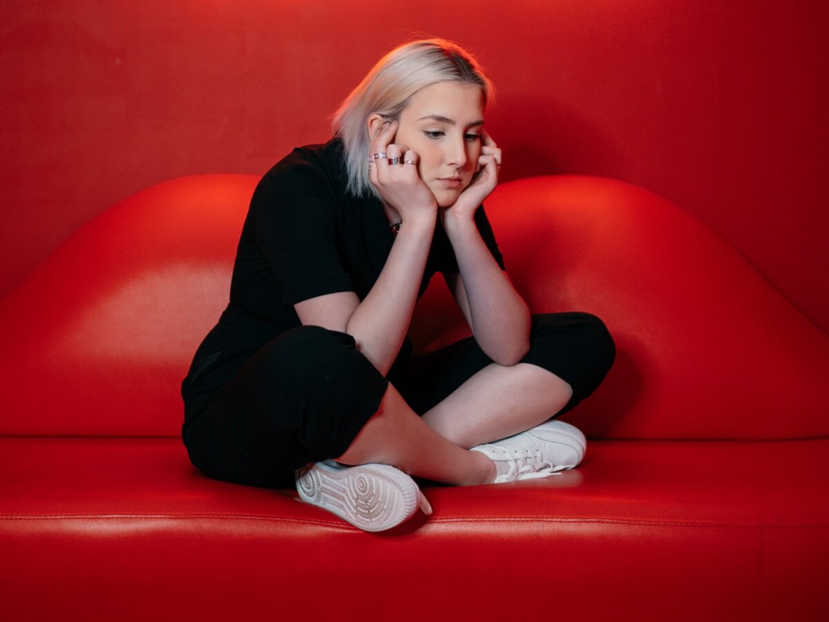 Une jeune femme assise qui semble pensive.