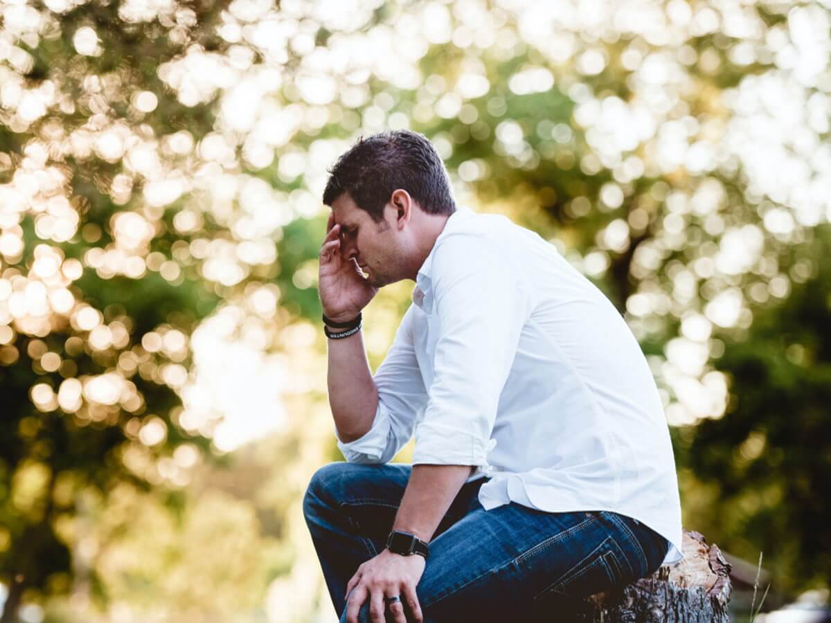 Un homme triste assis sur une souche