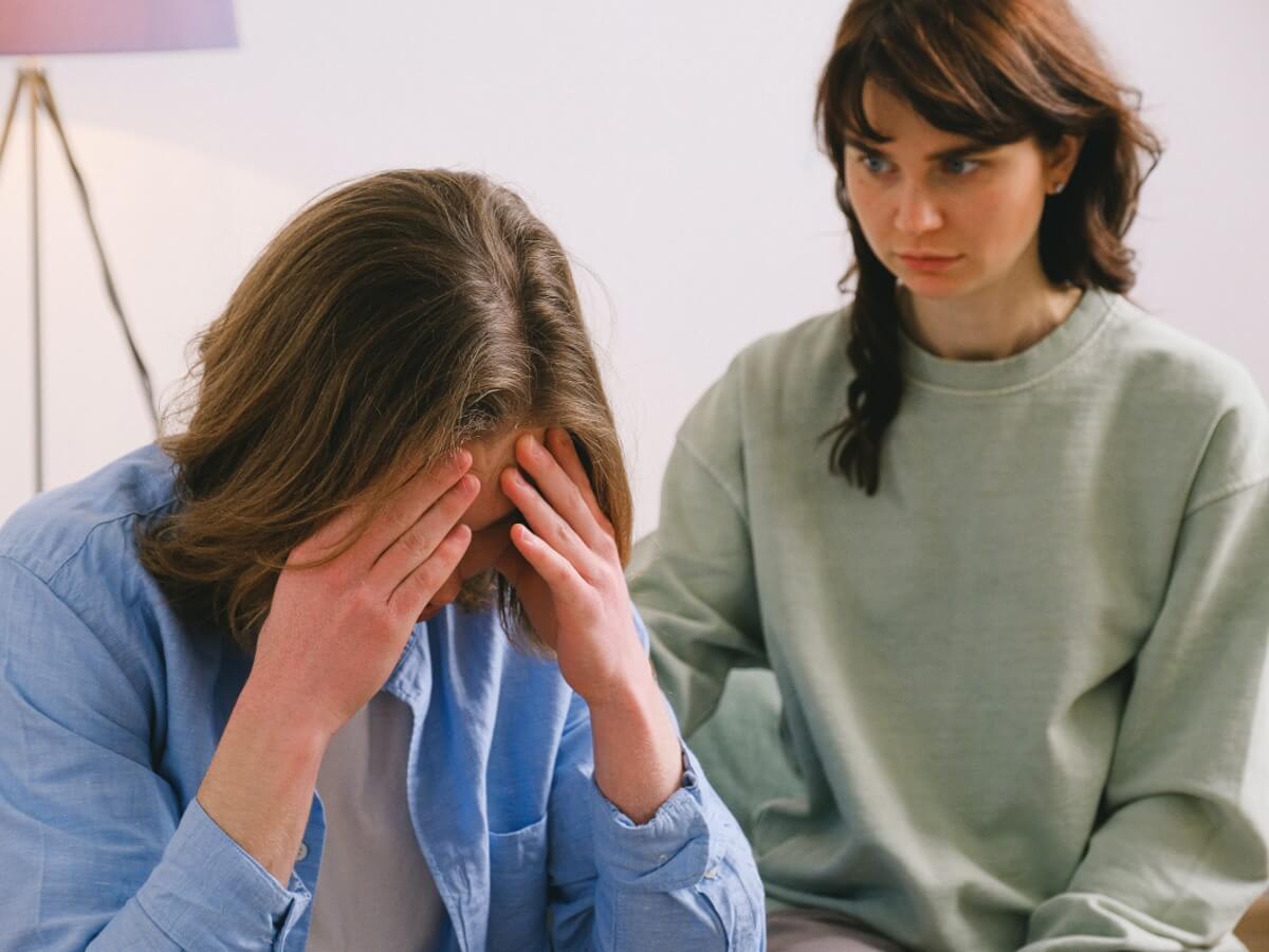Un jeune homme découragé est consolé par une jeune femme.