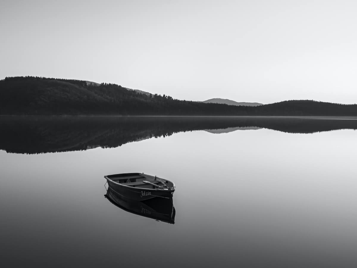 Une barque sur un lac immobile.