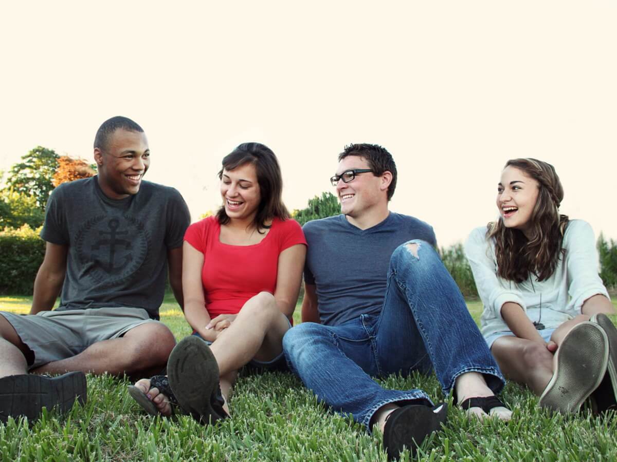 Quatre jeunes adultes rigolent ensemble.
