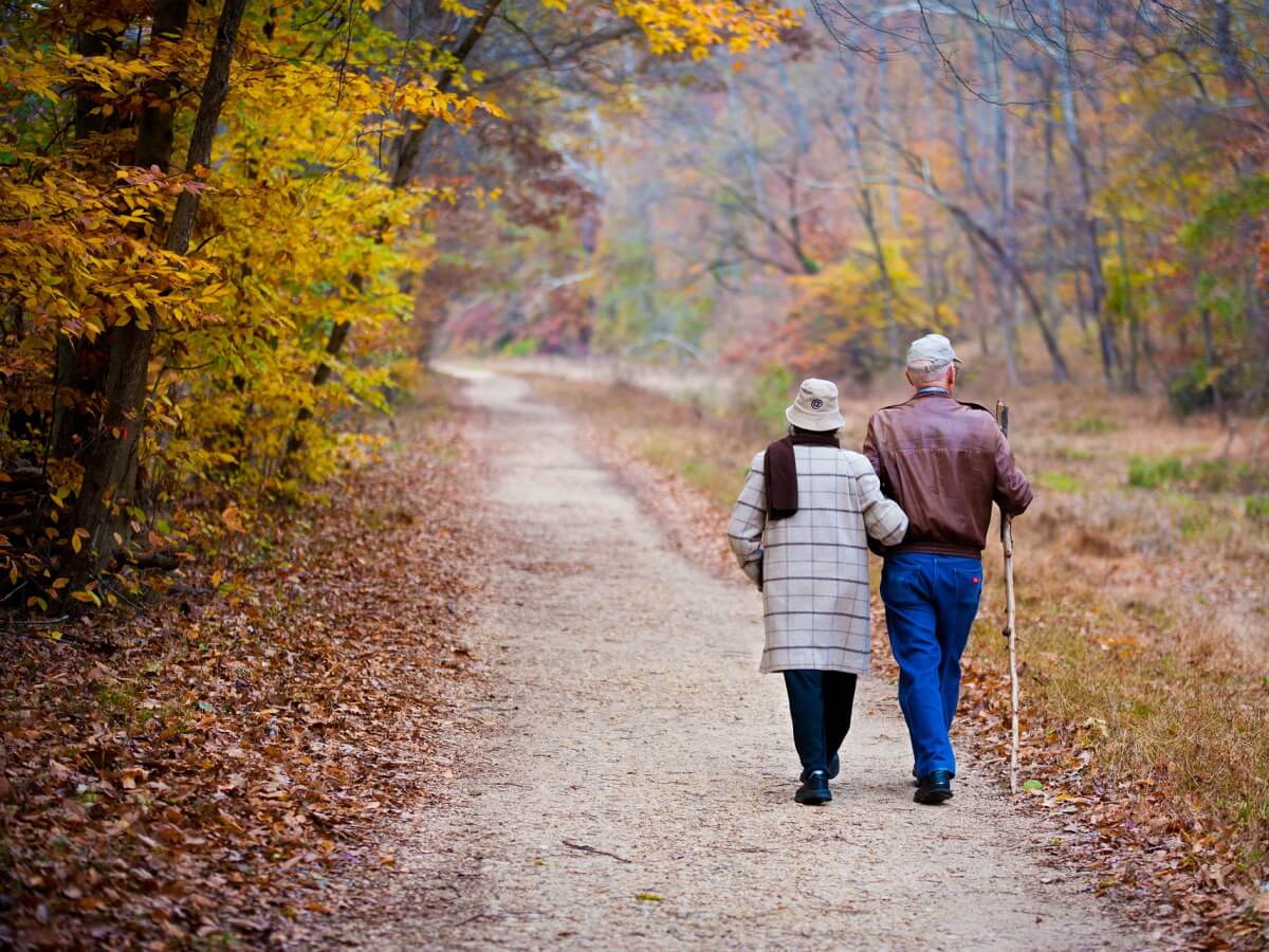 Un couple âgé marche main dans la main.