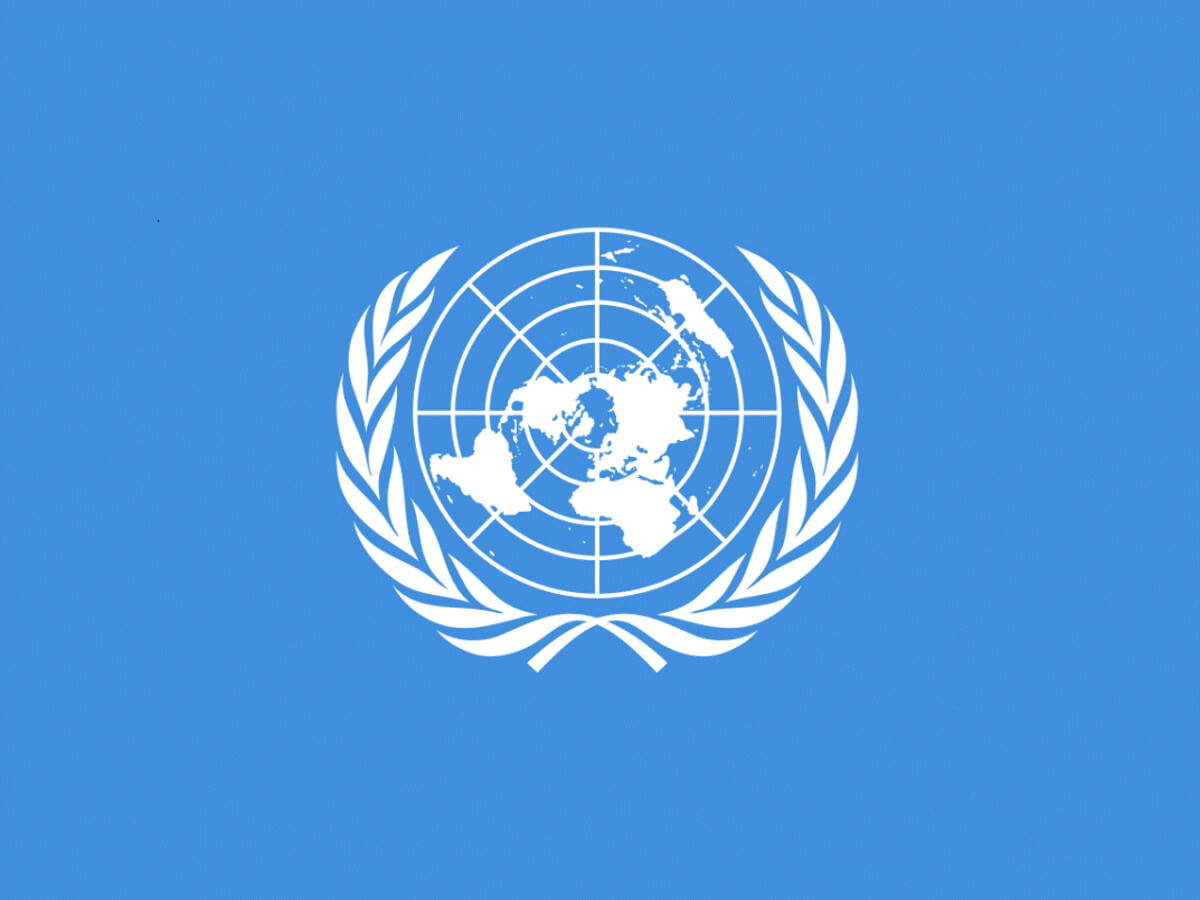 Drapeau des Nations unies : une carte du monde entourée de rameaux d'olivier sur fond bleu.