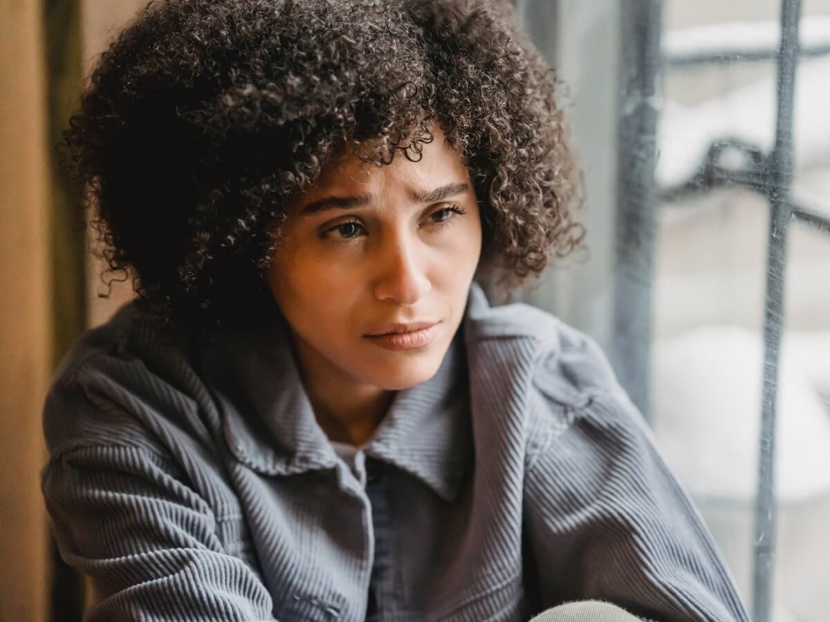 Une jeune femme assise au regard terriblement triste