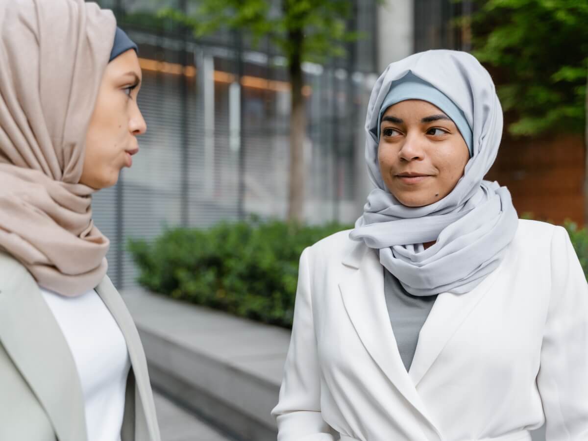 Une femme sourit en écoute une autre femme.
