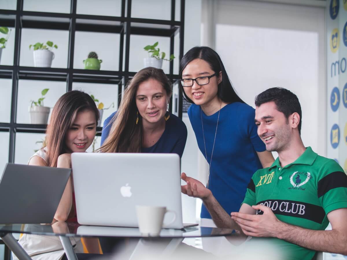 Trois dames regardent un écran d'ordinateur avec enthousiasme.