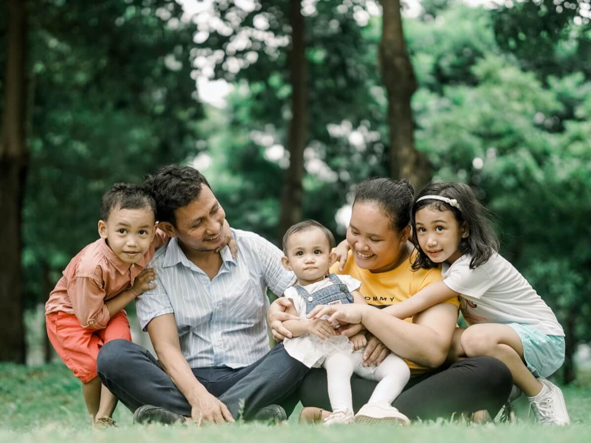 Un homme, une femme et 3 enfants sur du gazon.
