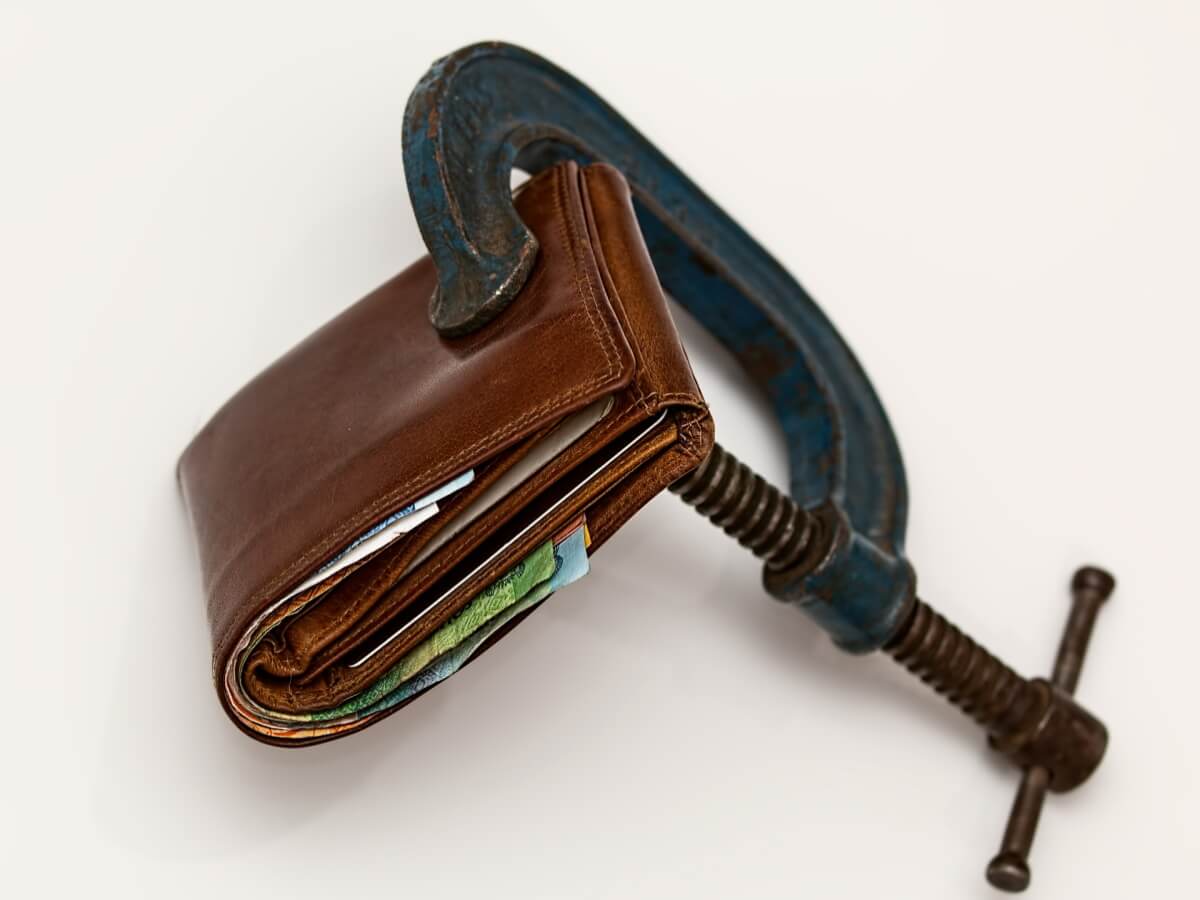 Un portefeuille serré dans un étau.