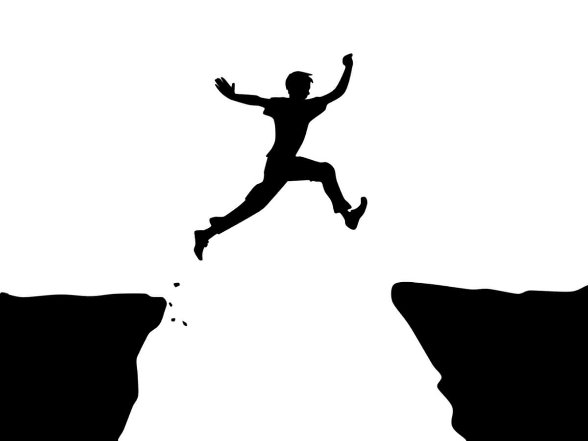Dessin d’un homme qui saute entre deux rochers.