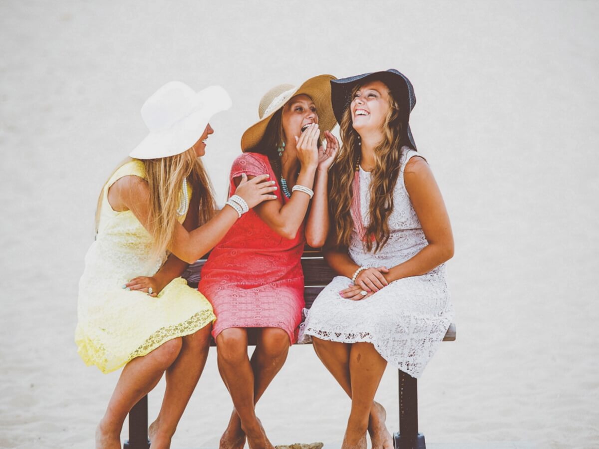 Trois jeunes femmes rient de bon cœur.