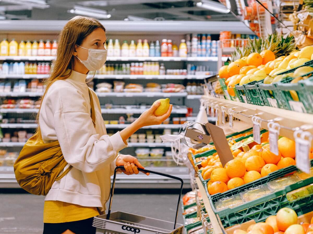 Une femme au super-marcher un citron à la main