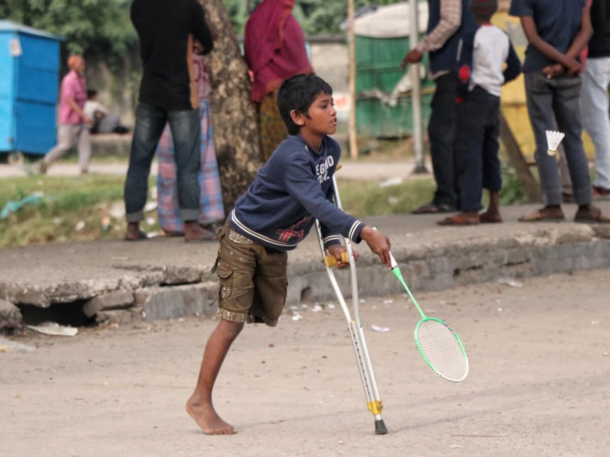 Un garçon handicapé joue au Badminton.