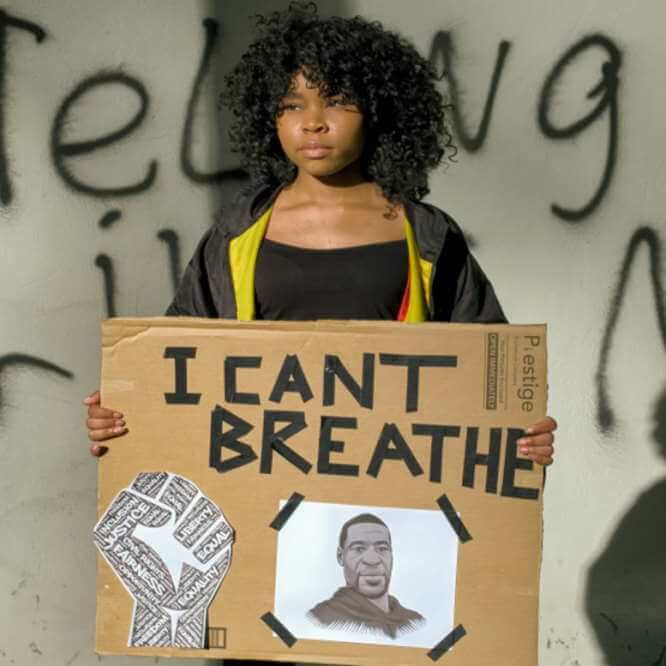 Une jeune femme tient un écriteau qui indique : I cant’t read