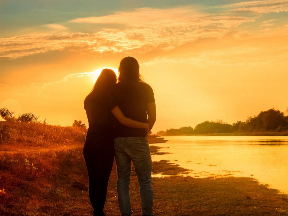 Deux amoureux marchent près d’une rivière.