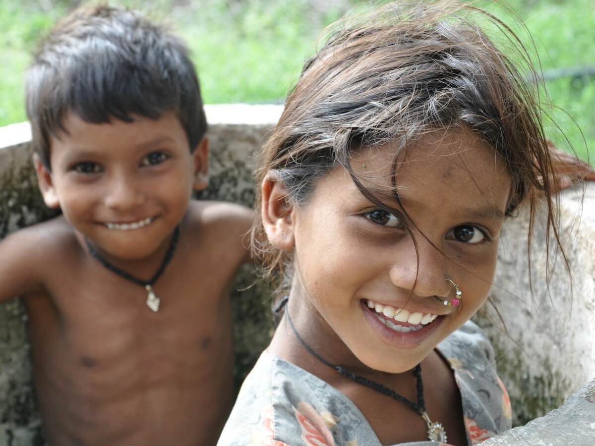 Deux enfants sourient largement.