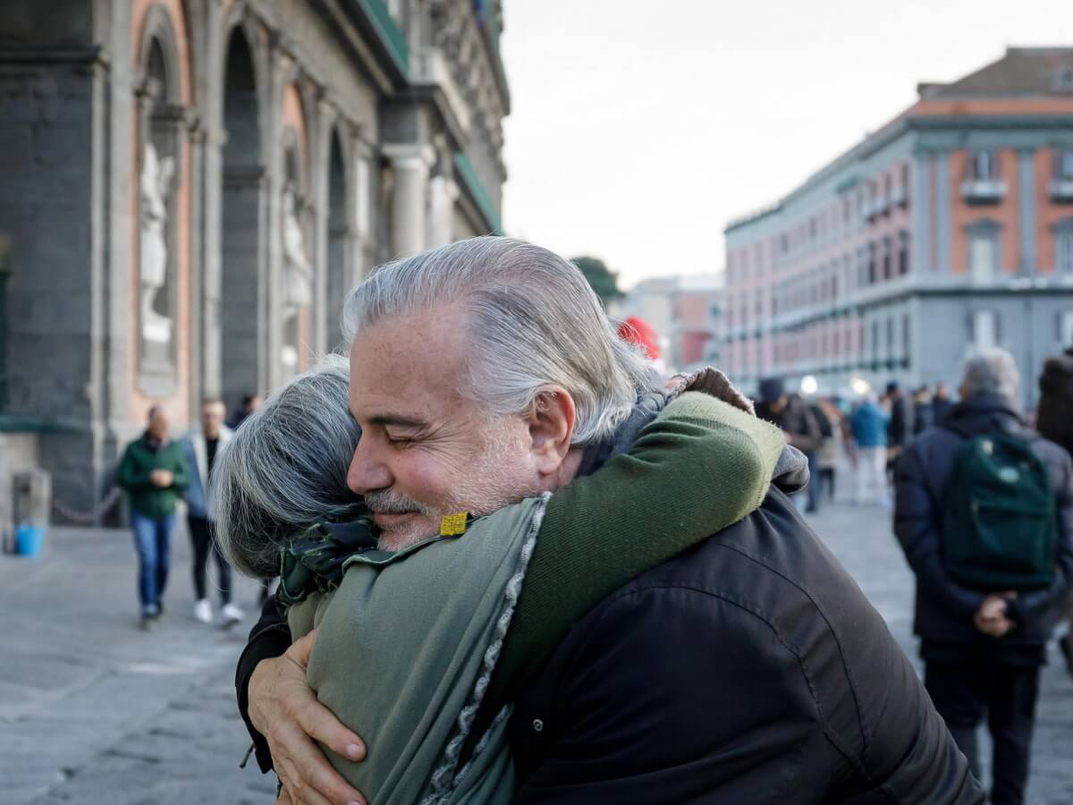 Un homme souriant prend une femme dans ses bras.