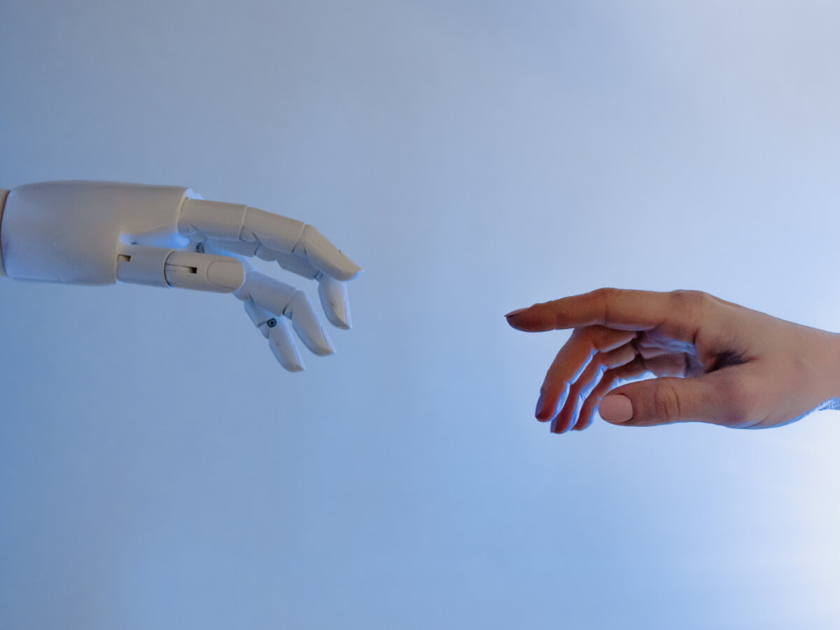 La main d’un robot s’approche d’une main humaine.