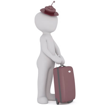 Une personne debout tient une valise à la main.