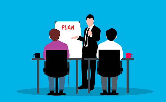 Une personne présente un plan devant un groupe.