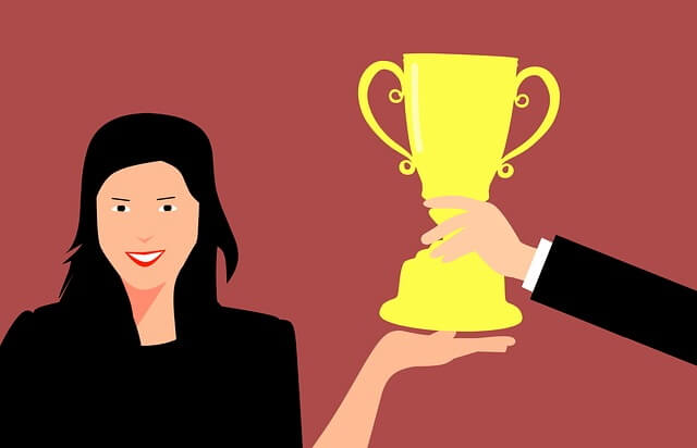 Une jeune femme reçoit un trophée.