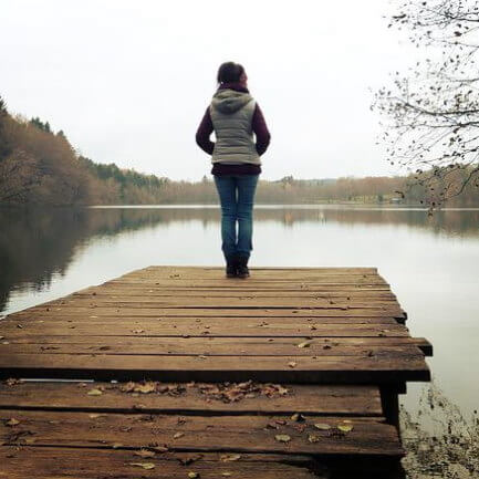 Une jeune femme seule près d’un lac