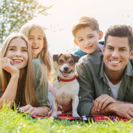 Une famille souriante autour d’un chien