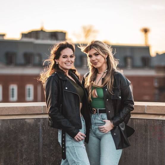 Deux jeunes femmes sourient ensemble.