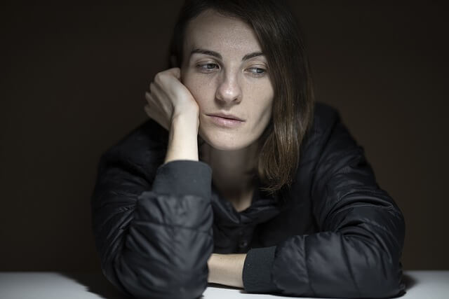 Gros plan sur une femme qui semble s’ennuyer.