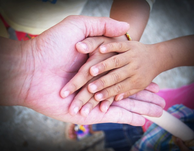 Des mains d’enfants dans une main d’adulte