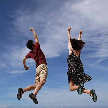 Un homme et une femme sautent de joie.