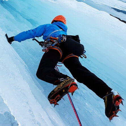 Un alpiniste grimpe une paroi de glace.