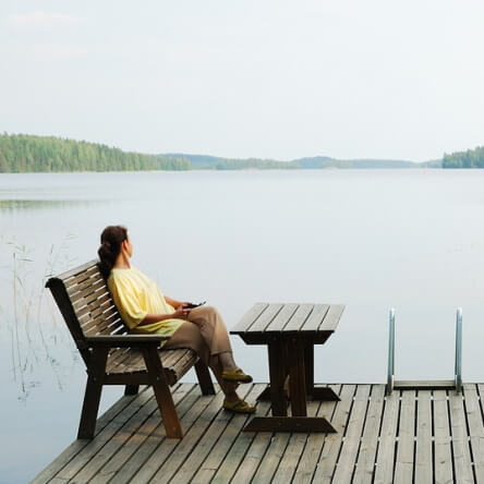 Une dame regarde calmement un lac naturel.
