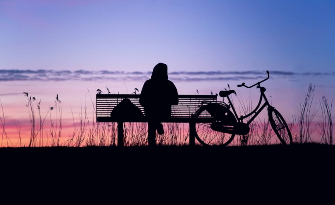  Assis sur un banc de parc devant un coucher de soleil
