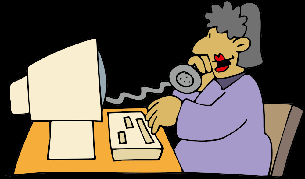 Une dame devant son ordinateur écoute le son de son téléphone.